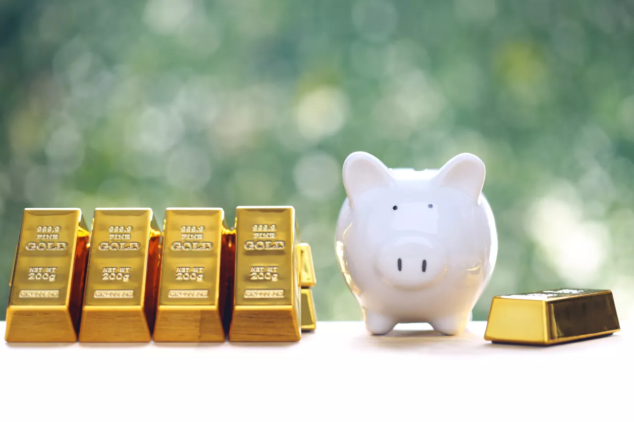 Sparschwein neben Goldbarren als Symbol für Altersvorsorge mit Gold